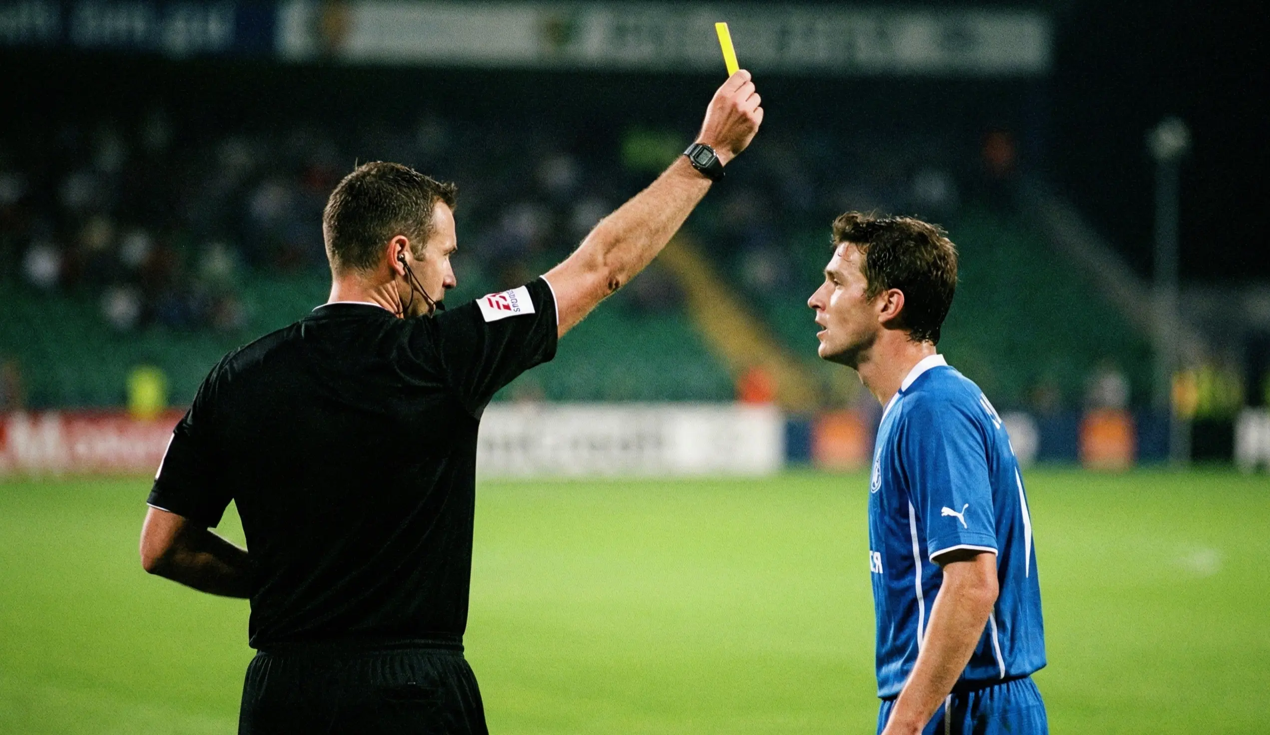 Referee showing a yellow card to a player during a football match