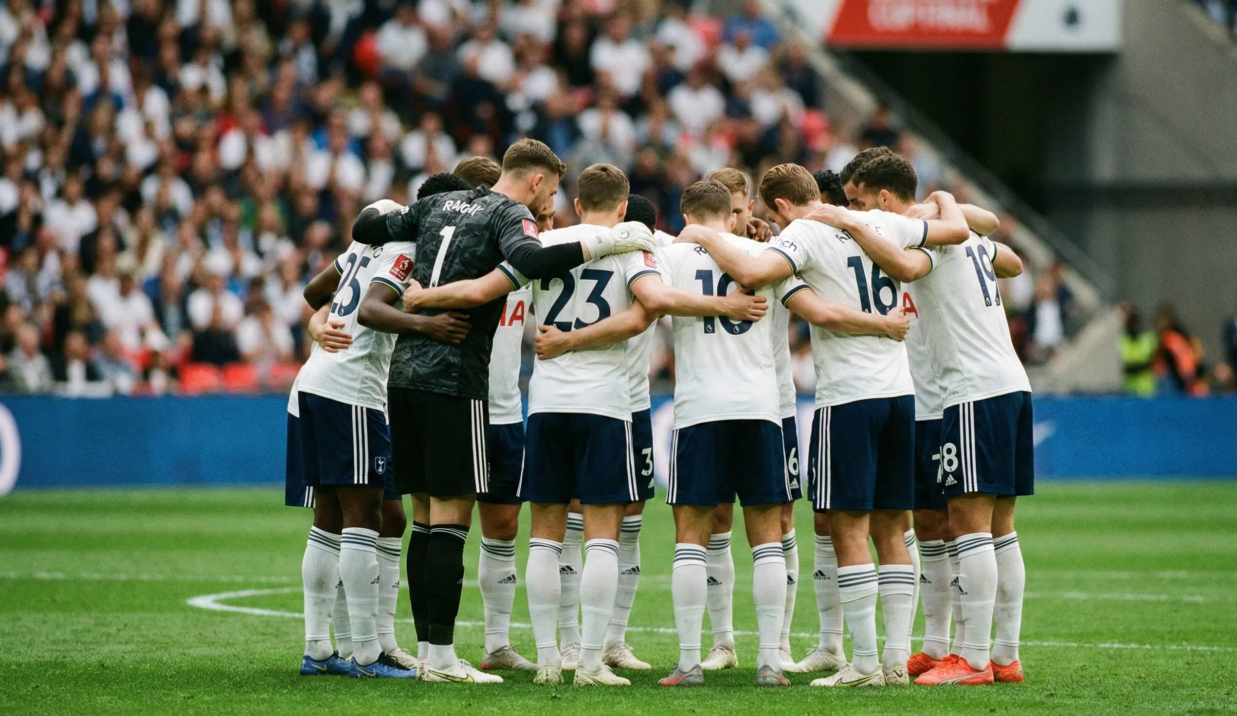 Football team in a huddle on the pitch before kickoff of an important match