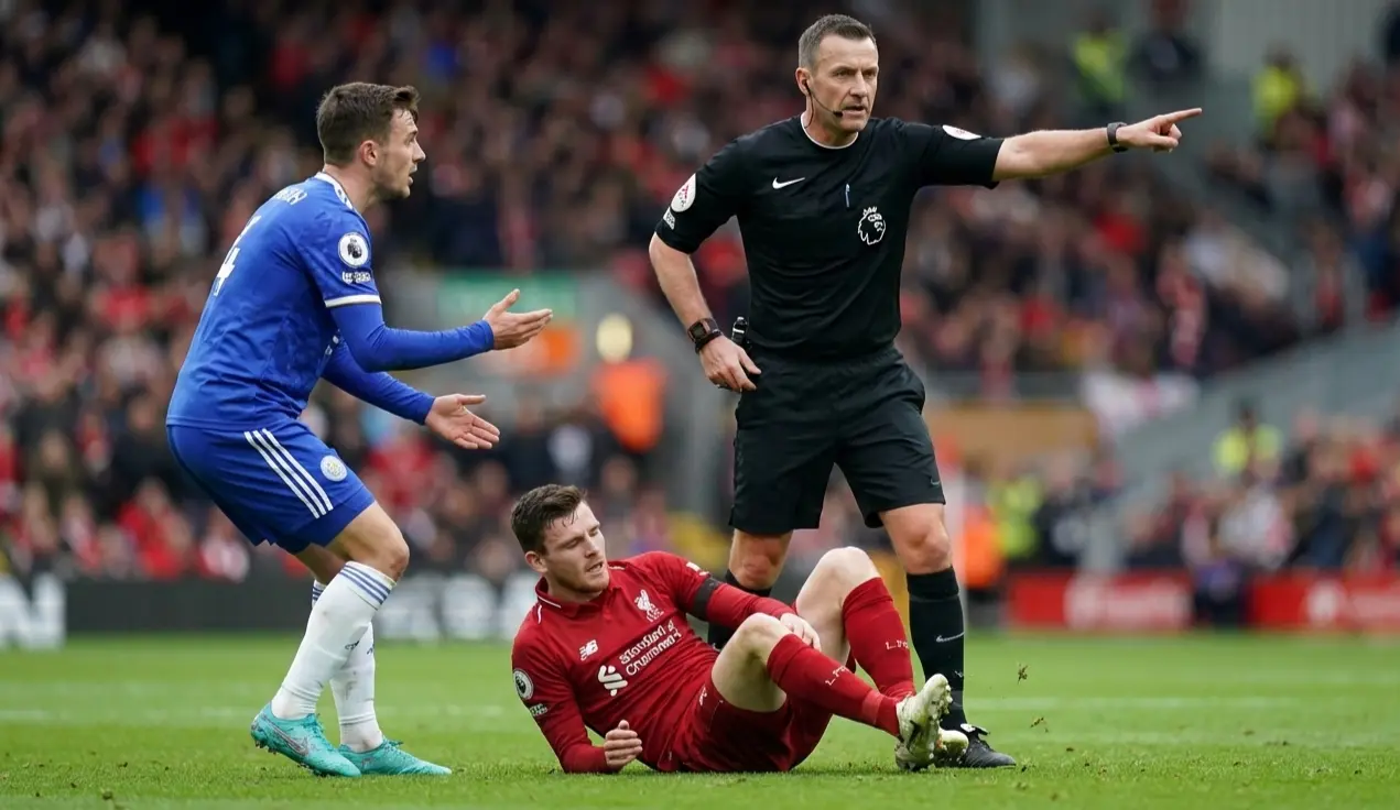 Football referee making a decision during a physical challenge between two players